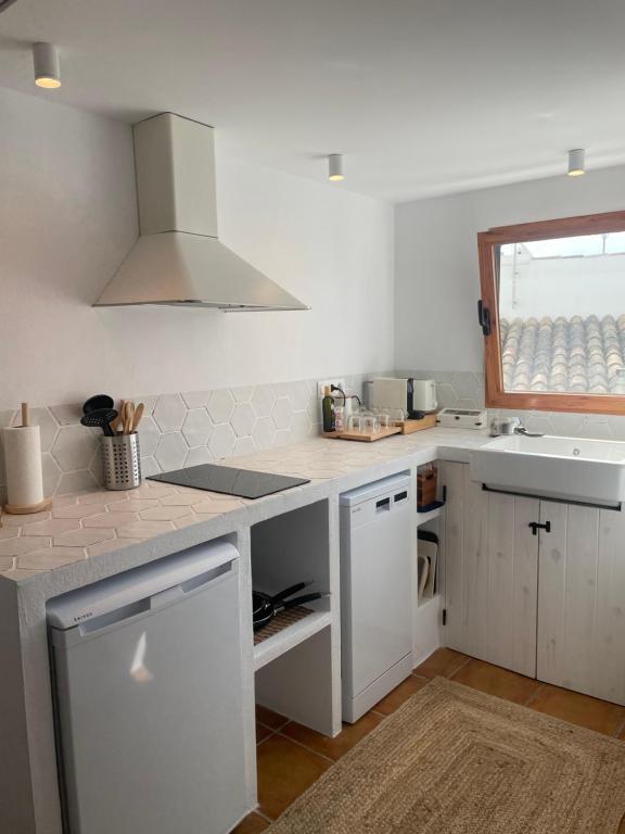 cocina blanca, suelo de madera y ventana