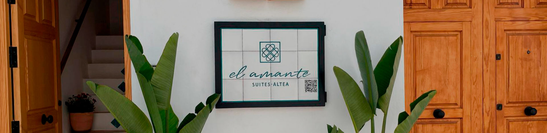 letrero el amante entre musas y portones de madera