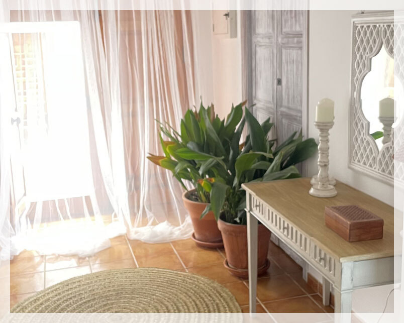 habitación con ventana abierta y mesita blanca y madera